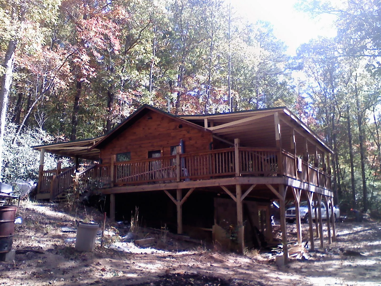 Log cabin with a wraparound porch and metal roof in the fall in Chattanooga